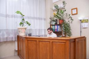 een man die aan een balie in een kamer zit bij Hotel Piligrim 3 in Nikolayev