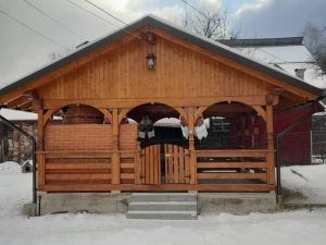 a large wooden gazebo with two animals on it at Casa Giorgiana in Statiunea Borsa