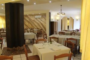 un comedor con mesas y sillas blancas en Agriturismo Agri Mediterraneo, en Capaccio-Paestum