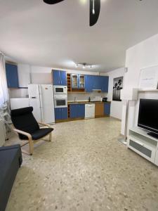 Precioso apartamento en el centro de Conil para familias, parejas y grupos في كونيل دي لا فرونتيرا: مطبخ مع خزائن زرقاء وأريكة وكرسي