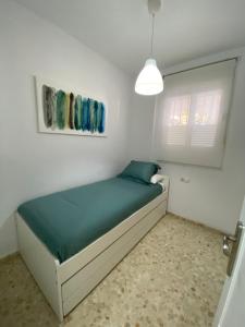 Precioso apartamento en el centro de Conil para familias, parejas y grupos في كونيل دي لا فرونتيرا: غرفة نوم بها سرير في غرفة بيضاء