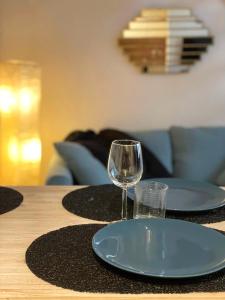 una mesa con dos platos y una copa de vino en ella en Du 5 au 7 - Le 7, en Obernai
