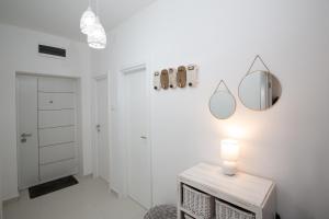 Dieses weiße Zimmer verfügt über einen Tisch mit einem Spiegel an der Wand. in der Unterkunft Park Apartment in Niksic in Nikšić