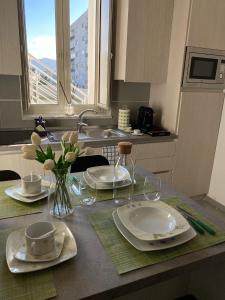 een keukentafel met borden en kopjes en een vaas met bloemen bij ILPOSTOGIUSTO in Torre Annunziata