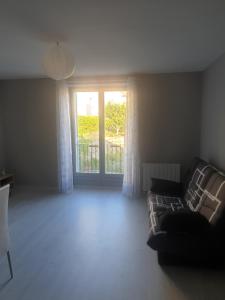 uma sala de estar com um sofá e uma janela em Appartement 4 couchages em Clairvaux-les-Lacs