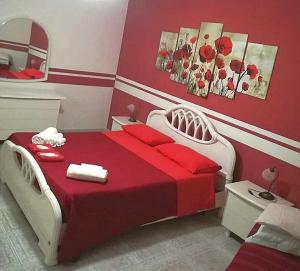 Un dormitorio con una cama roja y blanca y un espejo en Villa del Capo, en Capo Vaticano