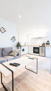 ein Wohnzimmer mit einem Sofa und einem Tisch in der Unterkunft L'Elégant - Idéal Couple - Parking Gratuit in Pau