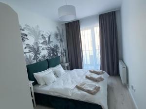 a bedroom with a bed with towels on it at Veles Apartments in Sibiu