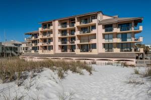 a large building on the beach next to the sand at Gulf Winds 101 in Pensacola Beach