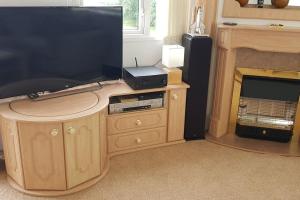 a living room with a television and a fireplace at 'Runway View' at Shobdon Airfield, Herefordshire in Shobdon