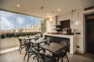 a restaurant with tables and chairs and a large window at Doria Palace Boutique Hotel in Rome