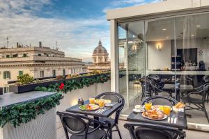 a balcony with tables and chairs and a view of the city at Doria Palace Boutique Hotel in Rome