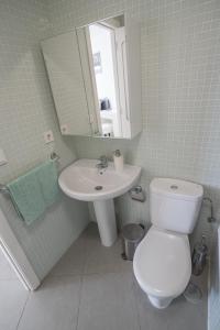 a bathroom with a toilet and a sink and a mirror at Modern sea view duplex with parking and aircon in El Médano +24 photos