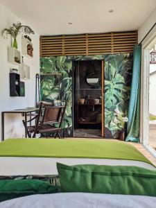 a bedroom with a green wall with a table and a bed at A LA KAZ TI ZOZEFF in Saint-Joseph