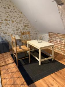 stół i 2 krzesła w pokoju z ceglaną ścianą w obiekcie Chambre en campagne w mieście Parence