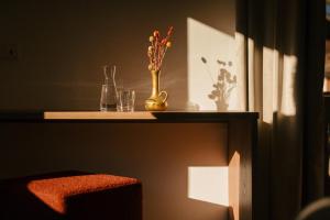une étagère avec un vase de fleurs et de verres dans l'établissement Hotel Gasthaus Post, à Campo di Trens