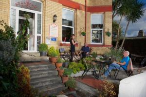 a group of people sitting outside of a building at Arrandale House in Douglas