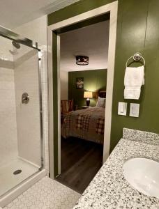 Lone Fir Resort في Cougar: حمام مع حوض وغرفة نوم مع سرير