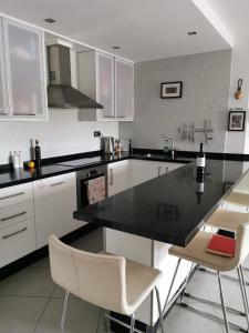 a kitchen with a black counter top and white cabinets at Modern sea view duplex with parking and aircon in El Médano
