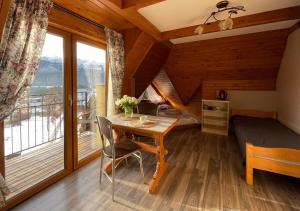 a bedroom with a table and a bed and a window at Wczasy Pod Giewontem in Kościelisko +48 photos