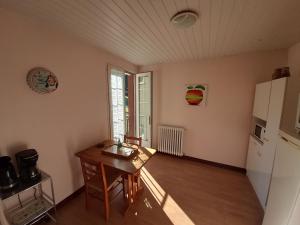 a small kitchen with a table and a refrigerator at LE CANTEGREL in Teillet