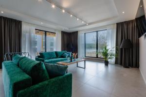 a living room with a green couch and a table at Hotel Odpocznia Resort i Las in Jaracz +38 photos