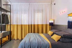 um quarto com uma cama e uma cortina amarela em MARCANTONIO HOME ROME - Vatican - em Roma