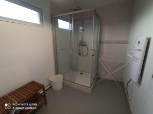 a bathroom with a shower and a bench in it at Gite HELSEBAN - Maison à 3 minutes de la mer dans résidence privée in Friaucourt