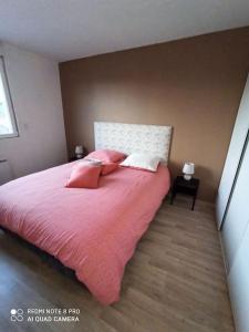 a bedroom with a large bed with pink sheets and pillows at Gite HELSEBAN - Maison à 3 minutes de la mer dans résidence privée in Friaucourt
