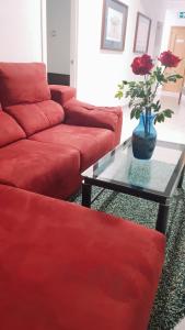 sala de estar con sofá rojo y mesa de cristal en Motel lavapies, en Madrid