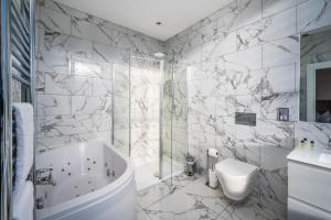 uma casa de banho com uma banheira, um WC e um lavatório. em Casa Fresa - Orchar Suites em Broughty Ferry