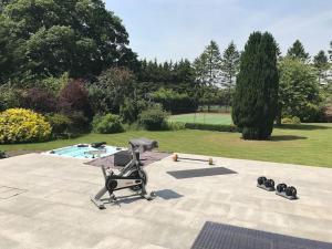 a baby stroller and weights on a patio with a pool at Stunning Oxfordshire 5 Bedroom House in 2 acres in Aston Rowant