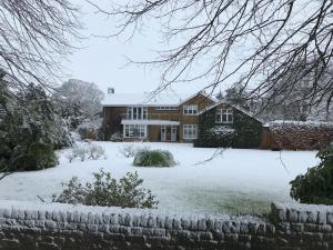 una casa con nieve en el suelo delante de ella en Stunning Oxfordshire 5 Bedroom House in 2 acres, en Aston Rowant