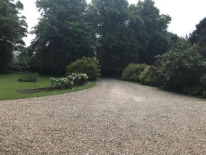a gravel driveway with trees in the background at Stunning Oxfordshire 5 Bedroom House in 2 acres in Aston Rowant