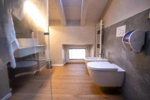 a bathroom with a toilet and two sinks and a window at Loft Roby in Peschiera del Garda