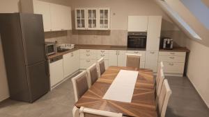 a kitchen with a wooden table and a refrigerator at Zichy Ház in Keszthely