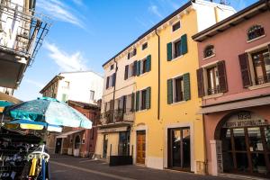 eine Straße mit Gebäuden und einem Regenschirm auf einer Straße in der Unterkunft Loft Roby in Peschiera del Garda