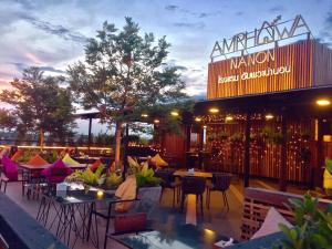 patio ze stołami i krzesłami oraz restauracja w obiekcie Amphawa Nanon Hotel w mieście Amphawa
