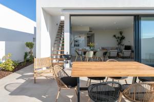 a patio with a wooden table and chairs at Casa de Cristal - Beautiful villa with private pool, 350m from beach, astonishing views in Mar de Cristal
