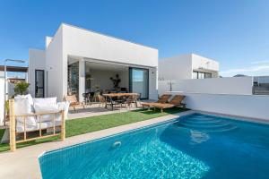 a villa with a swimming pool in front of a house at Casa de Cristal - Beautiful villa with private pool, 350m from beach, astonishing views in Mar de Cristal