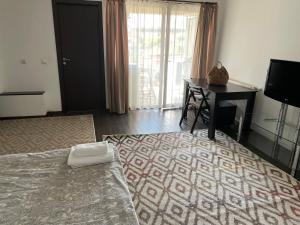 a bedroom with a bed and a desk and a television at En Passant / a time in Iasi in Iaşi