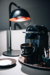 a black coffee maker on a table with plates at Clarion Hotel Gillet in Uppsala