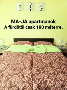 een slaapkamer met een bed met de woorden mia jaaennainx a f bij MA-JA 4 in Bük