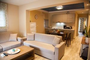a living room with two couches and a kitchen at Paporas Apartments in Svoronata