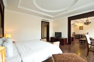 a bedroom with a white bed and a living room at LK Residence in Pattaya Central