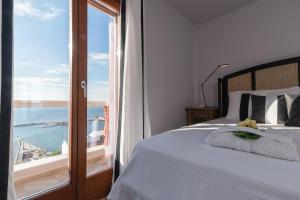 a bedroom with a bed with a view of the ocean at Archo Suites Pythagoreio in Pythagoreio