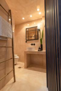 a bathroom with a sink and a toilet and a mirror at Archo Suites Pythagoreio in Pythagoreio