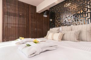 a bedroom with a white bed with towels on it at Archo Suites Pythagoreio in Pythagoreio