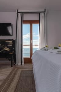 a bedroom with a bed and a window and a piano at Archo Suites Pythagoreio in Pythagoreio