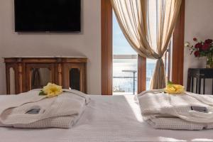 a bedroom with two towels on a bed with a window at Archo Suites Pythagoreio in Pythagoreio